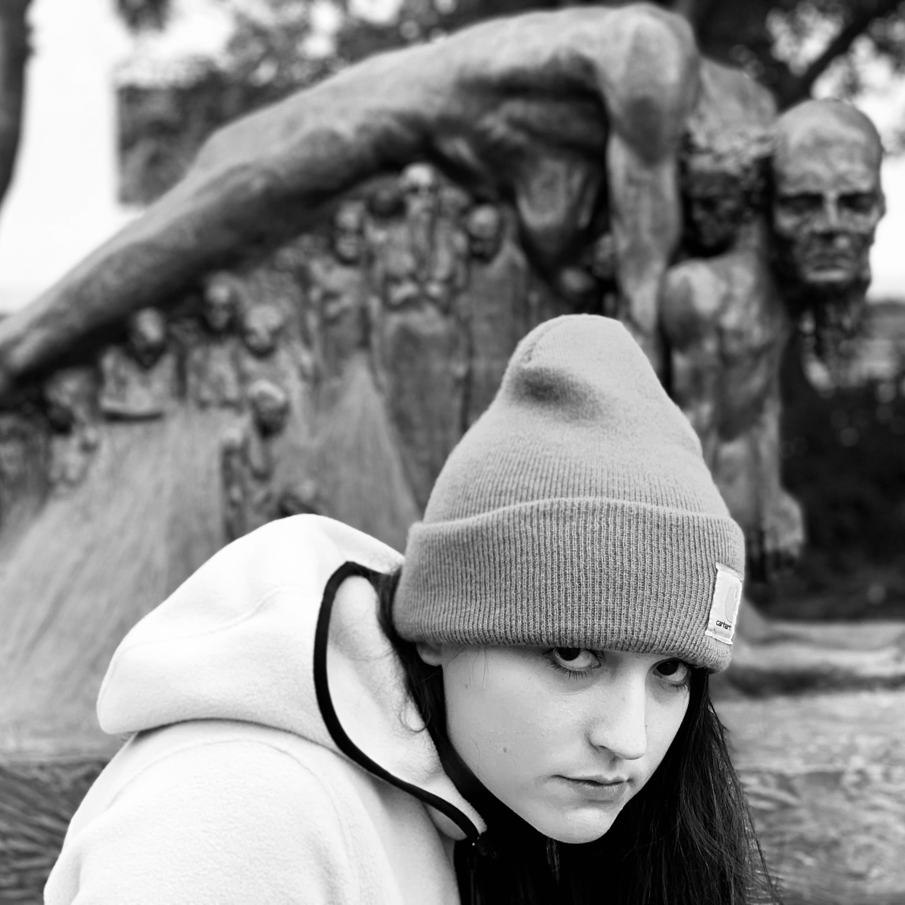 A black-and-white photo of Sarah Kuntz in front of a statue.